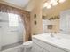 Well-maintained bathroom featuring a shower with curtain, single vanity, and decorative accents at 18514 Hidden Pines Way, Hudson, FL 34667