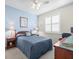 Comfortable bedroom featuring a queen bed, ceiling fan and natural light from the shuttered window at 18514 Hidden Pines Way, Hudson, FL 34667