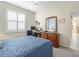 Bright bedroom with natural light from the shuttered window plus a computer desk and wooden dresser at 18514 Hidden Pines Way, Hudson, FL 34667