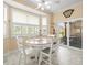 Light-filled breakfast nook with white table set, bay window, and sliding glass door to the patio at 18514 Hidden Pines Way, Hudson, FL 34667