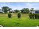 Well-manicured front lawn with neatly trimmed bushes and mature trees in a neighborhood setting at 18514 Hidden Pines Way, Hudson, FL 34667