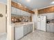Bright kitchen featuring tile floor, white appliances, light-gray cabinets, and decorative accents at 18514 Hidden Pines Way, Hudson, FL 34667