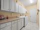 Clean laundry room offering ample storage, counter space, washer, and dryer at 18514 Hidden Pines Way, Hudson, FL 34667