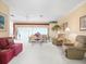Inviting living room with bright lighting, comfortable seating, and decorative floral arrangements at 18514 Hidden Pines Way, Hudson, FL 34667
