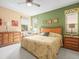 Relaxing main bedroom with a ceiling fan, soft lighting, floral drapes, and an inviting king bed at 18514 Hidden Pines Way, Hudson, FL 34667