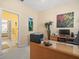 Bright office space with a large executive desk and decoratives accents and an ensuite bathroom at 18514 Hidden Pines Way, Hudson, FL 34667