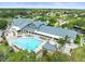 Aerial view of an inviting outdoor pool, lounge chairs, and clubhouse in a beautiful community at 18514 Hidden Pines Way, Hudson, FL 34667