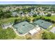 Aerial view of tennis courts and bocce ball courts with lush surroundings in a well-maintained neighborhood at 18514 Hidden Pines Way, Hudson, FL 34667