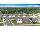 A panoramic aerial view shows the houses in the neighborhood with lush green trees and manicured lawns at 1876 Colding Dr, Ruskin, FL 33570