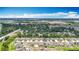 An aerial view of a neighborhood with modern single-Gathering homes under a blue sky, surrounded by lush greenery and trees at 1876 Colding Dr, Ruskin, FL 33570