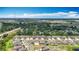 An aerial view of a neighborhood with modern single-Gathering homes under a blue sky, surrounded by lush greenery and trees at 1876 Colding Dr, Ruskin, FL 33570