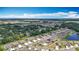 An aerial view showcases modern single-Gathering homes with solar panels, near a tranquil pond, embodying a peaceful neighborhood setting at 1876 Colding Dr, Ruskin, FL 33570