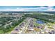 Aerial view showcasing a neighborhood near a pond, surrounded by lush greenery and modern homes, under a partly cloudy sky at 1876 Colding Dr, Ruskin, FL 33570