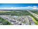 An aerial view captures a neighborhood with ponds, lush greenery, and a nearby highway, under a partly cloudy sky at 1876 Colding Dr, Ruskin, FL 33570