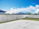 Concrete backyard with white fence and partial grass, offering a blend of low maintenance and green space at 1876 Colding Dr, Ruskin, FL 33570