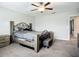 This primary bedroom features a ceiling fan, a sitting area, and a neutral color scheme at 1876 Colding Dr, Ruskin, FL 33570