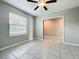 Bedroom with gray ceramic tile flooring, ceiling fan, and window with blinds at 1876 Colding Dr, Ruskin, FL 33570