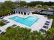 A community pool with a bathhouse, a recreational pool, lounge chairs, and manicured landscaping at 1876 Colding Dr, Ruskin, FL 33570
