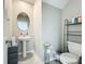 Stylish half bathroom features pedestal sink, neutral wall color and decorative shelving at 1876 Colding Dr, Ruskin, FL 33570