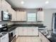 Kitchen featuring granite countertops, white cabinets, and stainless steel appliances at 1876 Colding Dr, Ruskin, FL 33570