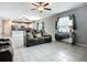 Open-concept living room with tile flooring, modern furniture, ceiling fan and kitchen view at 1876 Colding Dr, Ruskin, FL 33570