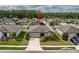 An aerial shot of a well-maintained house nestled in a neighborhood with lush trees in the background at 19041 Alfaro Loop, Spring Hill, FL 34610