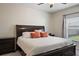 Bedroom features a dark wood bed frame, plush pillows, and a ceiling fan for added comfort at 19041 Alfaro Loop, Spring Hill, FL 34610