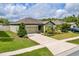Charming single-story home boasts a manicured lawn, inviting curb appeal, and an attached two-car garage at 19041 Alfaro Loop, Spring Hill, FL 34610
