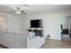 Cozy living room with wood-look flooring, ceiling fan, and large television at 19041 Alfaro Loop, Spring Hill, FL 34610