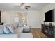 Bright and airy living room, offering wood-look tile, a large couch and a tv at 19041 Alfaro Loop, Spring Hill, FL 34610