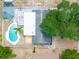 Overhead view showcases a house with a unique pool, patio, lush greenery, and outbuilding at 202 Cranberry Ln, Brandon, FL 33510