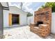 Wide angle view of the detached garage, outdoor fireplace and patio area at 202 Cranberry Ln, Brandon, FL 33510