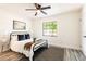 Cozy bedroom with a black metal bed frame, ceiling fan and view from an updated window at 202 Cranberry Ln, Brandon, FL 33510
