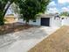 Charming single-story home with a long driveway, dark garage door, and a well-maintained yard at 202 Cranberry Ln, Brandon, FL 33510
