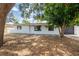 Charming single-story home with white textured exterior and a well-maintained lawn with mature trees at 202 Cranberry Ln, Brandon, FL 33510