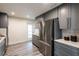 Updated kitchen with stainless steel appliances, gray cabinetry, and wood-look flooring at 202 Cranberry Ln, Brandon, FL 33510