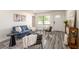 Stylish living area with a comfortable blue sofa, modern accents, and sleek wood-style floors at 202 Cranberry Ln, Brandon, FL 33510