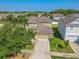 Two story home with manicured lawn featuring two car garage, palm tree, and landscape features at 20404 Autumn Fern Ave, Tampa, FL 33647