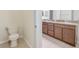 View into the bathroom with a toilet and double sink vanity with granite counters at 20404 Autumn Fern Ave, Tampa, FL 33647