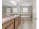Bathroom featuring double sinks, a soaking tub, a glass enclosed shower, and tile flooring at 20404 Autumn Fern Ave, Tampa, FL 33647