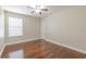 Spacious bedroom with wood floors, a ceiling fan, and natural light from the window at 20404 Autumn Fern Ave, Tampa, FL 33647