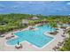 This home boasts access to a stunning community pool area with seating, a clubhouse, and mature trees at 20404 Autumn Fern Ave, Tampa, FL 33647