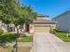 Charming two-story home with a well-manicured front yard, large tree and a red front door at 20404 Autumn Fern Ave, Tampa, FL 33647