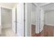 Hallway leading to a bathroom and bedroom with hardwood floors and white doors at 20404 Autumn Fern Ave, Tampa, FL 33647