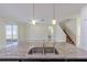 Granite kitchen island with a double sink and view into the living area and staircase at 20404 Autumn Fern Ave, Tampa, FL 33647