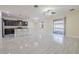 Spacious living room with modern gray floors and a large kitchen island with seating at 20404 Autumn Fern Ave, Tampa, FL 33647
