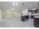 Open floor plan combining kitchen, living, and dining spaces with modern gray floors at 20404 Autumn Fern Ave, Tampa, FL 33647