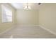 Spacious living room area with large window, chandelier and contemporary tile flooring at 20404 Autumn Fern Ave, Tampa, FL 33647