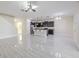 Open-concept living space with tile flooring, kitchen island, dark cabinets, and modern fixtures at 20404 Autumn Fern Ave, Tampa, FL 33647