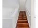 View of the wood staircase with white banister and modern floors; entryway to upper level at 20404 Autumn Fern Ave, Tampa, FL 33647